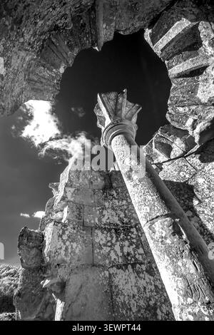 Dramatic monochrome image of a spiral staircase remains reaching towards the sky at English Heritage Wardour Castle in Wiltshire UK Stock Photo