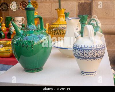 Colorful handcrafted pottery and artisanal ceramics are for sale at an outdoor market Stock Photo