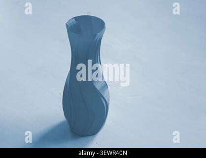 Object in form of vase printed on 3D printer. Three-dimensional model printed on 3D printer from molten plastic of red color. Concept 3D Printing. FDM 3D Printing technology Stock Photo