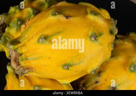 Close-up texture of yellow dragon fruit skin on black background Stock Photo