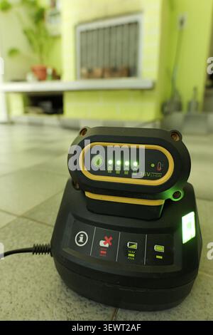Lithium ion battery pack charging on an electronic power station, with indicator lights showing the battery is fully charged, representing modern tech Stock Photo