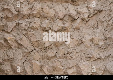 Beige stone wall texture inspired by traditional Arabic architecture. Handcrafted rough surface with natural cracks and layered stones.  Stock Photo