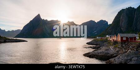 Sunset over Lofoten fjord with rorbuer and jagged peaks near Ryten Stock Photo