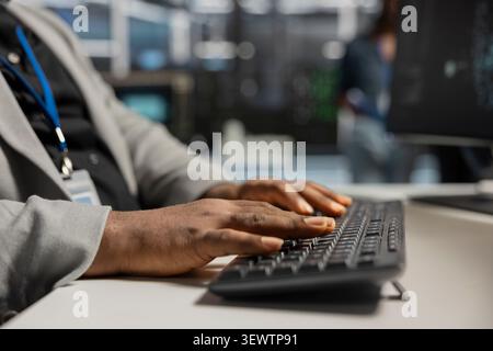 Data center technician uses a desktop computer in a data center to run hardware diagnostics and maintain operational stability. Stock Photo
