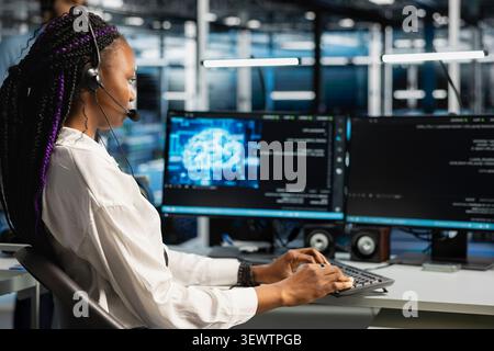 Administrator wears a headset in a server hub, using artificial intelligence troubleshooting to assist users. Stock Photo