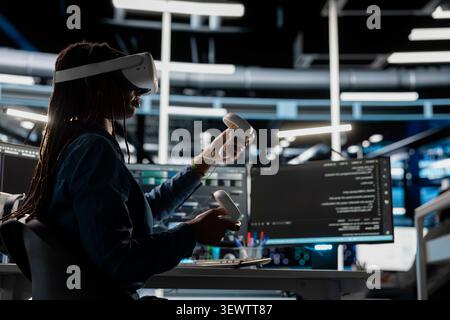 Data center engineer uses a VR headset in a data center to manage AI systems, train neural networks, and configure hardware. Stock Photo