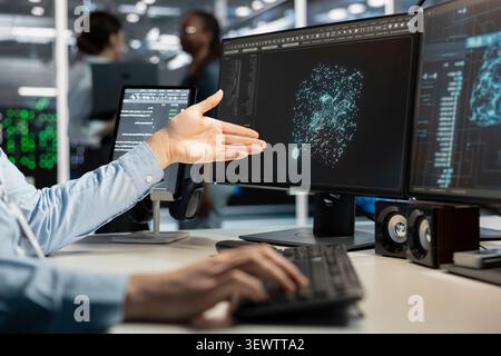 Data center programmer uses a desktop computer in a data center to manage AI virtualization and optimize server infrastructure. Stock Photo