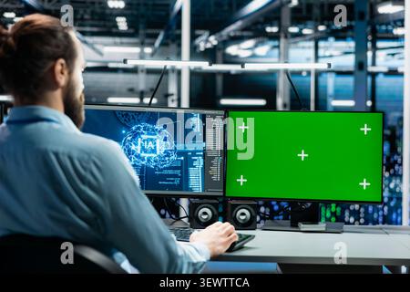 Software developer uses a green screen computer to manage AI systems, machine learning workflows and server performance. Stock Photo