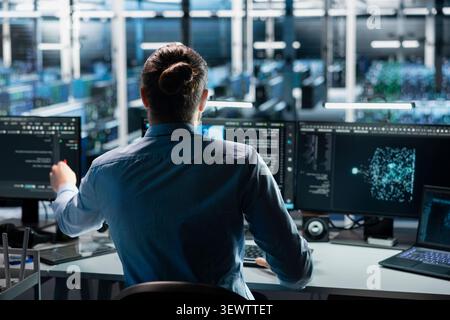 Engineer uses an AI language model assistant in a server room to handle infrastructure maintenance. Stock Photo