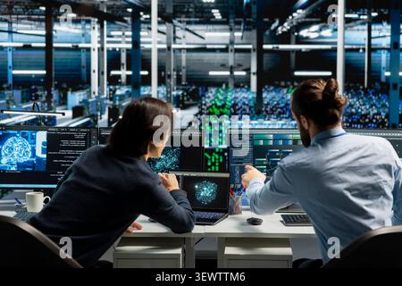 System administrator reviews artificial intelligence systems and machine learning processes inside a data center. Stock Photo