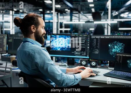Smiling data center technician uses a computer to review server infrastructure, diagnostics and AI technology in a data center. Stock Photo
