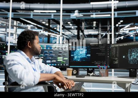 Engineer with paraplegia uses AI visualization tools in an inclusive data center to find bugs and detect system errors. Stock Photo