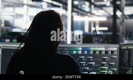 Data center engineer reviews artificial intelligence systems and machine learning processes inside a data center. Stock Photo