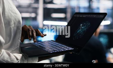Data center technician reviews AI systems and neural network parameters on a tablet inside a data center. Stock Photo