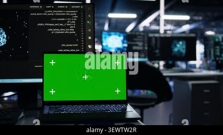 IT specialist works with a laptop in a server hub to support artificial intelligence systems. Stock Photo