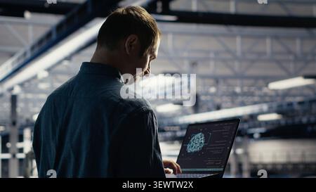 Technician monitors server room activity working with laptop while walking through facility. Stock Photo
