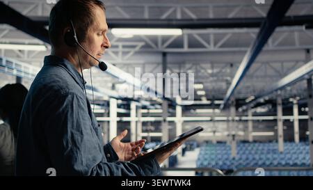 IT specialist uses digital device in a server farm to plan disaster recovery and strengthen data protection. Stock Photo