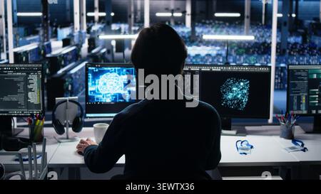 Data infrastructure center system administrator working on AI neural network software development, while implementing machine learning technology in workplace. Stock Photo