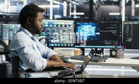 Data center specialist in wheelchair uses node tree AI software to analyze infrastructure and identify issues in a data center. Stock Photo