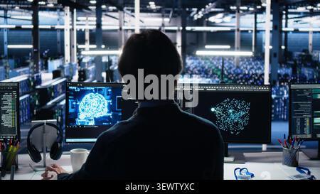Software developer programs on a computer workstation in a server farm with generative AI assistance. Stock Photo