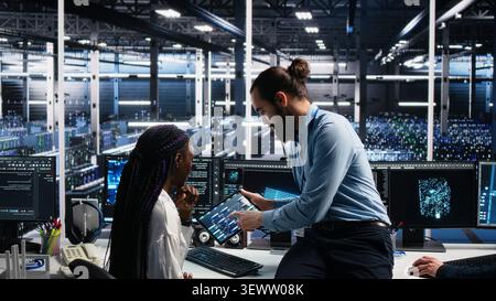 Data infrastructure center engineering team members collaborating on neural network software development, while implementing machine learning technology in workplace. Stock Photo