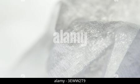 Abstract white and light gray fabric texture with subtle weave softly focused featuring an ethereal gradient for ample copy space. Stock Photo
