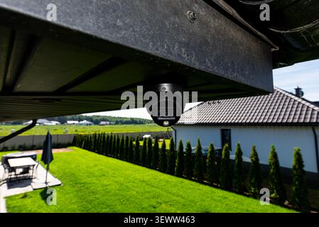 Dome security camera monitoring a residential yard, providing surveillance and privacy Stock Photo