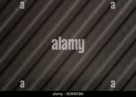 Dark textured fabric shows soft pleats and subtle sheen. Even lighting highlights ridges and natural material depth. Suitable for minimalist design or Stock Photo