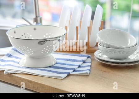 Clean kitchenware drying on wooden countertop Stock Photo