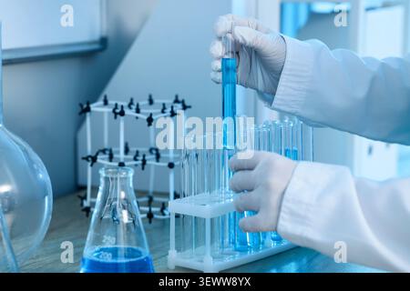 Scientist handling blue liquid in test tube in laboratory Stock Photo