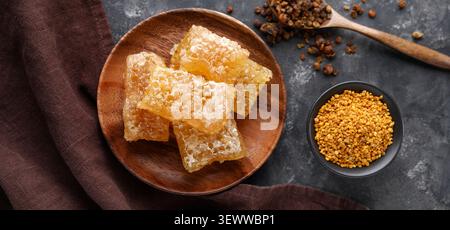 Honeycomb pieces with bee pollen on dark surface Stock Photo