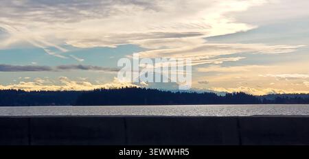 Mount Rainier (Tahoma) Rising Above Lake Washington Beneath Dramatic Clouds at Sunset Stock Photo