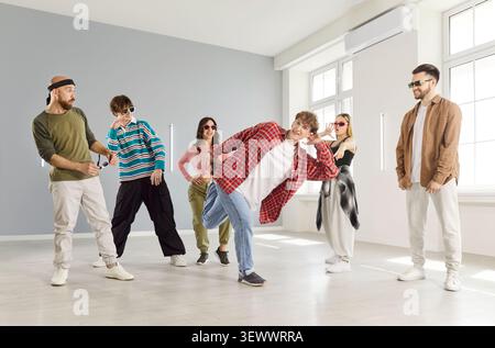 Hip hop dancer man, group of dancing people dancing indoors, moving posing in studio space Stock Photo