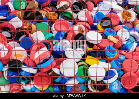 Colorful plastic bottle caps collected in a recycling container. Concept of plastic recycling, waste sorting, reusable materials, reducing plastic pol Stock Photo