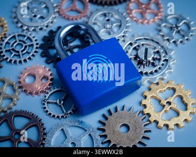 Industrial cybersecurity concept featuring biometric padlock among mechanical gears. Operational technology security, secure manufacturing, industrial Stock Photo