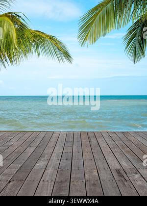 Tropical ocean view with wooden deck and palm leaves framing blue sea horizon, featuring exotic travel destination, summer vacation background, coasta Stock Photo