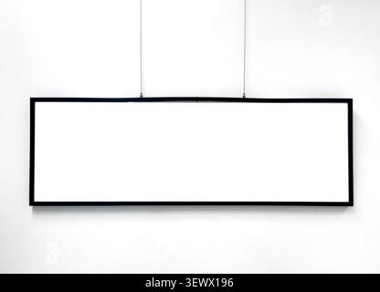 Long horizontal frame hangs on wall with empty blank space. Minimal mock up design allows insertion of artwork into clean template. Interior concept r Stock Photo