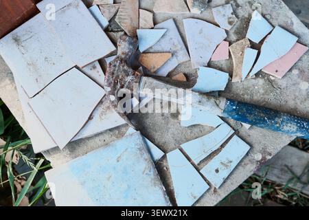 Hammer and broken ceramic tiles during DIY home renovation. Upcycling old materials Stock Photo