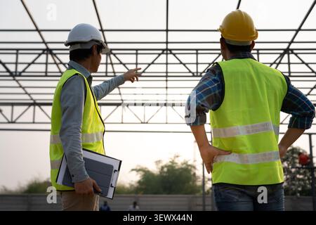 Engineers team use laptop and check the blueprint on site. Contractor and inspector inspection construction during project.civil Forman check quality Stock Photo