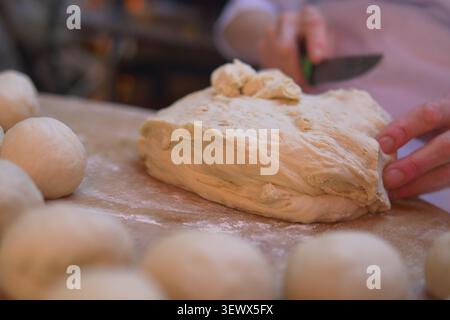 Baker kneads dough and prepares for bread making in kitchen Stock Photo