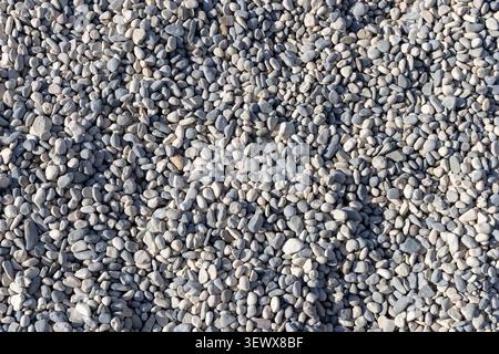 Background of beach pebbles on Adriatic coast in Croatia. Soft, smooth stones in natural tones create serene, minimal seaside aesthetic perfect for tr Stock Photo