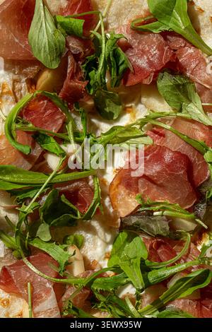 Prosciutto pizza with fresh rocket close up Stock Photo