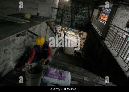 A worker installs floor tiles on a staircase inside the Zocalo-Tenochtitlan metro station in Mexico City, Mexico, on May 18, 2026. The transit hub is undergoing a comprehensive aesthetic and functional renovation ahead of the 2026 World Cup. Serving approximately 13 million passengers annually, the station connects directly to the Fan Fest site and is receiving updated installations, including new murals and hydroponic green walls. (Photo by Xavier Duarte/Middle East Images/StringersHub/Sipa USA) Stock Photo