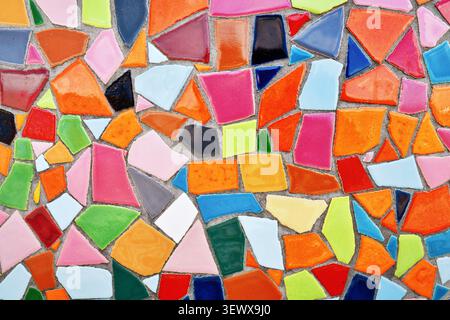 Close up of wall made of irregular small colorful mosaic stones, uneven textured decorative surface with vibrant pattern Stock Photo