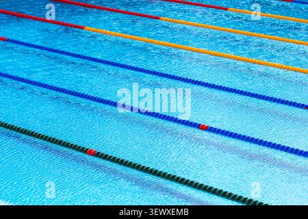 Empty olympic swimming pool lanes with blue and yellow float dividers and clear water ripples Stock Photo
