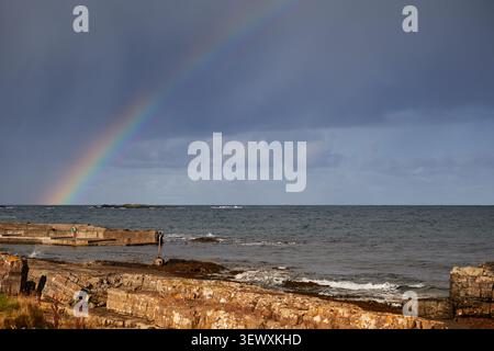 Rainbow over the Atlantic coastline with rocky shore in Ireland Stock Photo