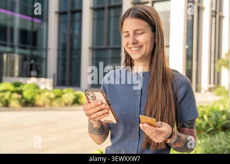 Woman making online purchase with smartphone and credit card Stock Photo