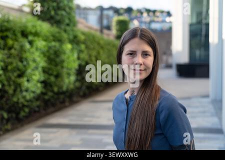 Young woman smiling outdoors in urban setting Stock Photo
