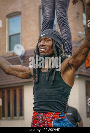 Smiling tattooed man lifts partner on shoulders Stock Photo