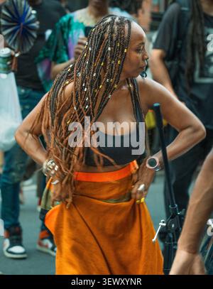 Black woman with long box braids dancing at a street festival Stock Photo